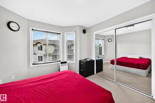 Room with light gray walls, plush carpet flooring, and a corner window arrangement - #72 2505 42 St Nw, Edmonton, AB - Indoor Photo Showing Bedroom