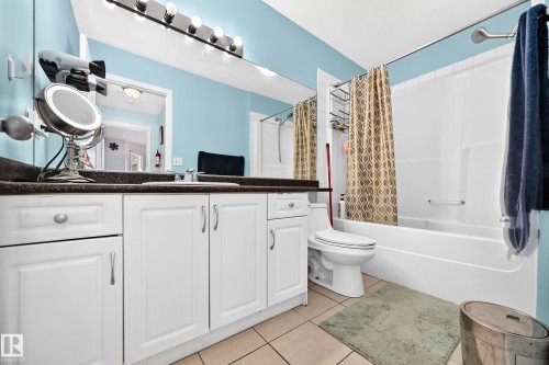 Bathroom featuring a built-in vanity with white cabinetry, a dark countertop, and a single basin sink - #72 2505 42 St Nw, Edmonton, AB - Indoor Photo Showing Bathroom