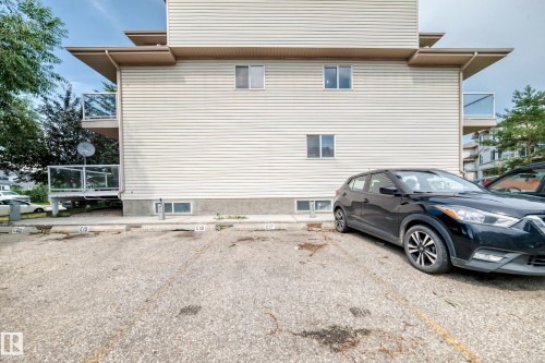 Multi-story building exterior featuring light-colored horizontal siding and multiple balconies with glass railings - #72 2505 42 St Nw, Edmonton, AB - Outdoor With Exterior