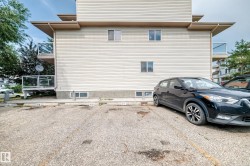 Multi-story building exterior featuring light-colored horizontal siding and multiple balconies with glass railings - 