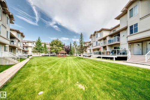 Expansive central green space featuring manicured lawn and mature trees - #72 2505 42 St Nw, Edmonton, AB - Outdoor