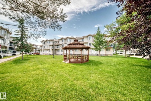 Central greenspace featuring a wooden gazebo with integrated seating, surrounded by mature trees - #72 2505 42 St Nw, Edmonton, AB - Outdoor