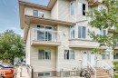 Multi-level townhouse exterior featuring light-toned horizontal siding, multiple windows, an upper-level balcony with glass railing, and a ground-level entrance with steps - #72 2505 42 St Nw, Edmonton, AB  - Outdoor With Facade 