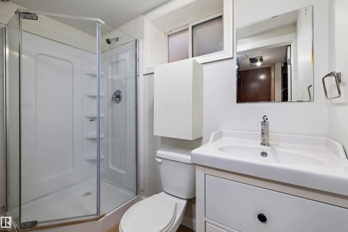 The downstairs bathroom has new subfloor and vinyl plank flooring, and vanity. - 9747 66 Avenue Nw, Edmonton, AB - Indoor Photo Showing Bathroom