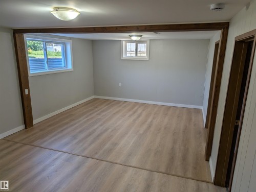 Extra large windows provide natural light. The luxury vinyl plank was installed in 2026. - 9747 66 Avenue Nw, Edmonton, AB - Indoor Photo Showing Other Room