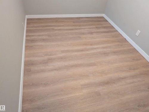 New luxury vinyl plank flooring in 2026. Both basement bedrooms have large hopper style windows allowing for egress in case of emergency. - 9747 66 Avenue Nw, Edmonton, AB - Indoor Photo Showing Other Room