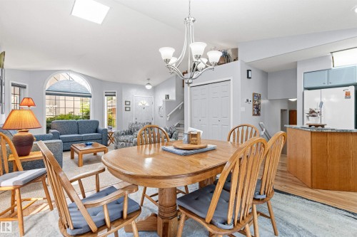 Open-concept living area featuring a skylight, arched window, and wood-finish flooring - #12 64 Blackburn Dr W Sw, Edmonton, AB - Indoor Photo Showing Dining Room