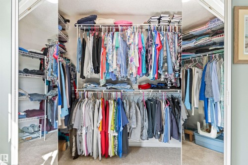 Wardrobe with wire shelving system and multiple hanging rods for optimized storage - #12 64 Blackburn Dr W Sw, Edmonton, AB - Indoor With Storage