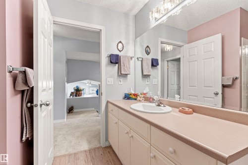 Bathroom vanity with an integrated sink, expansive mirror, and overhead lighting - #12 64 Blackburn Dr W Sw, Edmonton, AB - Indoor Photo Showing Bathroom