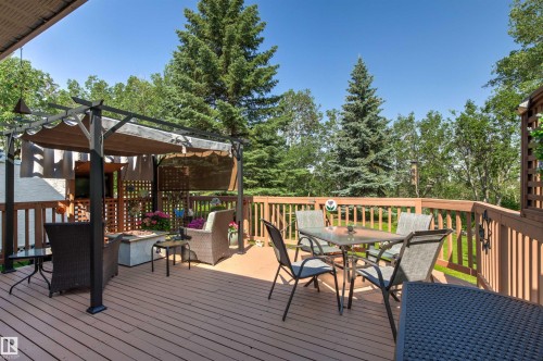 Expansive outdoor deck featuring wood-finish flooring, a metal pergola with retractable canopy, and a slatted wood railing - #12 64 Blackburn Dr W Sw, Edmonton, AB - Outdoor With Deck Patio Veranda With Exterior