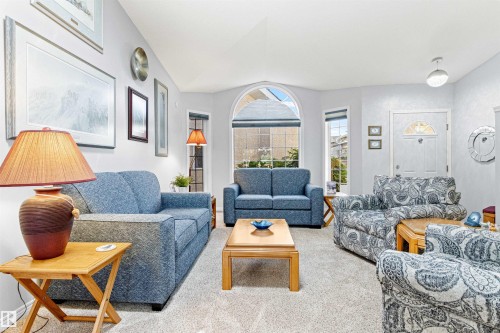 Living area featuring vaulted ceilings and light-toned wall finishes - #12 64 Blackburn Dr W Sw, Edmonton, AB - Indoor Photo Showing Living Room