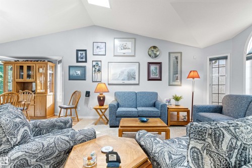 Vaulted ceilings with skylights enhance this bright living area - #12 64 Blackburn Dr W Sw, Edmonton, AB - Indoor Photo Showing Living Room