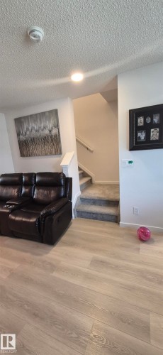 Open concept living area featuring wood-finish flooring, recessed lighting, and a carpeted staircase - 22803 94 Anenue Northwest, Edmonton, AB - Indoor Photo Showing Other Room