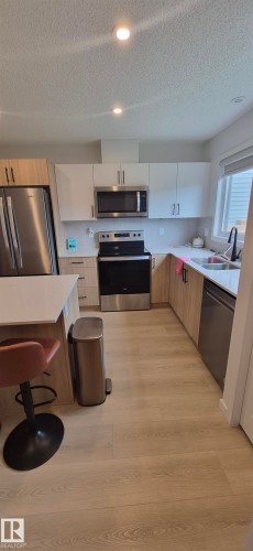 U-shaped kitchen featuring wood-finish flooring and recessed lighting - 22803 94 Anenue Northwest, Edmonton, AB - Indoor Photo Showing Kitchen With Double Sink