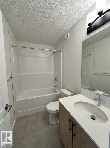 Bathroom featuring a vanity with a light wood-finish cabinet, a white countertop, and a rectangular undermount sink - 22803 94 Anenue Northwest, Edmonton, AB - Indoor Photo Showing Bathroom