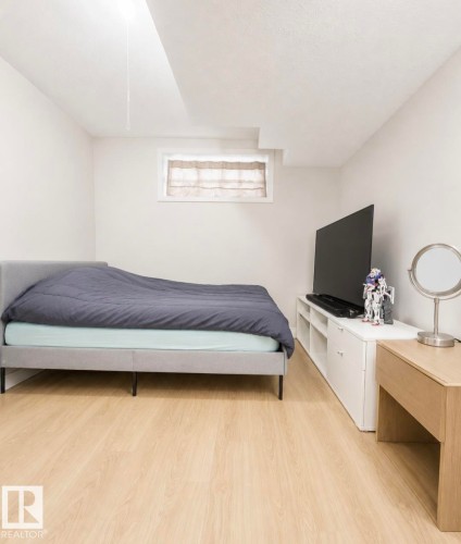 Bright room featuring wood-finish flooring and a window with a fabric shade - 3236 27 Avenue Nw, Edmonton, AB - Indoor Photo Showing Bedroom