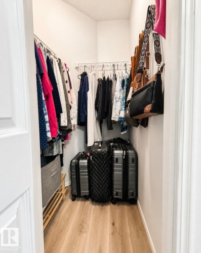 Functional walk-in closet featuring light wood-finish flooring - 3236 27 Avenue Nw, Edmonton, AB - Indoor With Storage