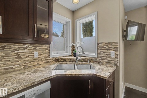 Corner kitchen sink featuring a gooseneck faucet, dual basin, and light-toned countertop - 1047 Leger Boulevard Nw, Edmonton, AB - Indoor Photo Showing Kitchen With Double Sink With Upgraded Kitchen