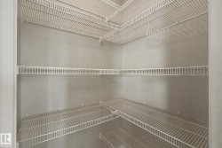 Spacious corner pantry featuring multiple tiers of white wire shelving, providing extensive storage capacity - 