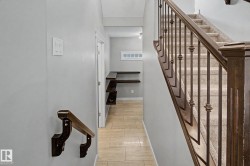 Staircase featuring dark wood handrails and balusters, carpeted treads, and light gray wall paint - 