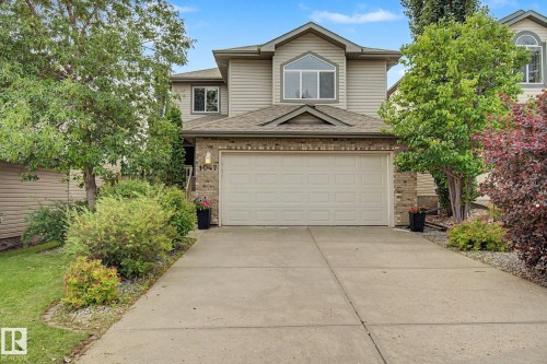 Two-story residence featuring light-colored siding and brick accents - 1047 Leger Boulevard Nw, Edmonton, AB - Outdoor