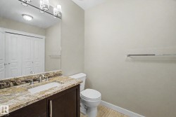 Bathroom vanity featuring a polished stone countertop with an integrated sink and chrome fixtures - 