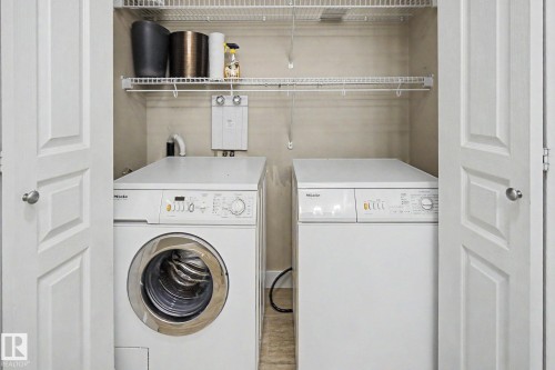 Dedicated laundry closet featuring bi-fold doors, a stacked washer and dryer, and overhead wire shelving - 1047 Leger Boulevard Nw, Edmonton, AB - Indoor Photo Showing Laundry Room