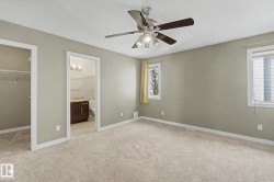 Spacious room featuring neutral carpeting, light neutral wall color, and a ceiling fan with integrated lighting - 