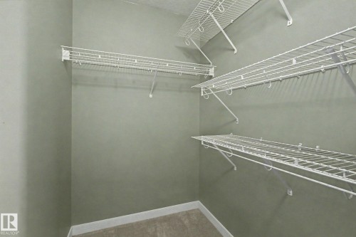 Closet featuring white wire shelving, hanging rods, and light gray wall paint - 1047 Leger Boulevard Nw, Edmonton, AB - Indoor With Storage