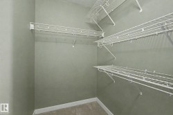 Closet featuring white wire shelving, hanging rods, and light gray wall paint - 