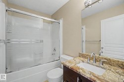Bathroom featuring a vanity with a granite countertop, undermount sink, and brushed nickel faucet - 