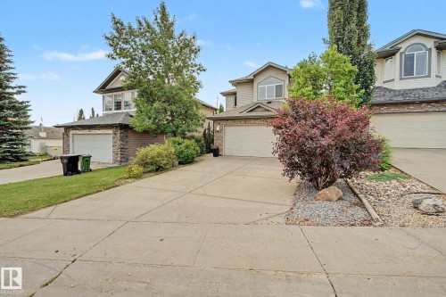 Two-story home with a stone and siding exterior, an attached garage, and a concrete driveway - 1047 Leger Boulevard Nw, Edmonton, AB - Outdoor