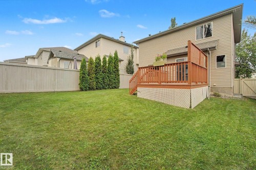 Spacious backyard featuring a large elevated deck with wood railings, lattice skirting, and privacy screen - 1047 Leger Boulevard Nw, Edmonton, AB - Outdoor With Deck Patio Veranda