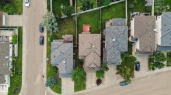 Aerial perspective showcasing a residential street with homes featuring pitched roofs and mature landscaping - 