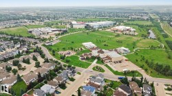 Aerial perspective showcasing residential properties and extensive green spaces - 