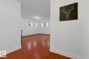 Bright interior space with wood-finish flooring, white walls, and multiple windows - #3 9955 114 St Nw, Edmonton, AB  - Indoor Photo Showing Other Room 