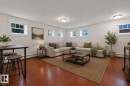 Bright living area with warm wood-finish flooring, multiple windows, and recessed lighting - #3 9955 114 St Nw, Edmonton, AB  - Indoor Photo Showing Living Room 