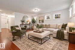 Spacious living area featuring rich wood-finish flooring and multiple windows for abundant natural light - 