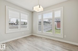 Expansive room featuring wood-finish flooring, light grey walls, and white trim - 