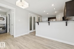 Light wood-finish flooring extending into the kitchen area - 