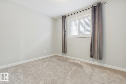 Light-toned wall paint and plush carpeting establish a neutral backdrop - 4058 Morrison Way Nw, Edmonton, AB - Indoor Photo Showing Other Room