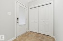 Entryway featuring a white door with a glass insert and digital lock, bifold closet doors, and patterned tile flooring - 4058 Morrison Way Nw, Edmonton, AB  - Indoor Photo Showing Other Room 