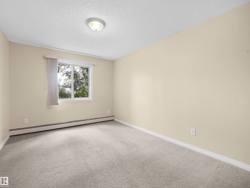 Room featuring neutral-toned walls, light-colored carpeting, and a white trim baseboard - #220 245 Edwards Dr Sw, Edmonton, AB - Indoor Photo Showing Other Room