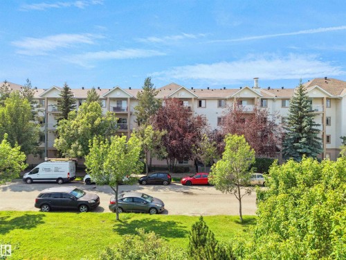 Multi-story residential building with light-toned siding and multiple balconies - #220 245 Edwards Dr Sw, Edmonton, AB - Outdoor