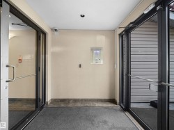 Entryway featuring double glass doors with metal frames and handles, recessed ceiling lighting, a security camera, and a tiled threshold - 