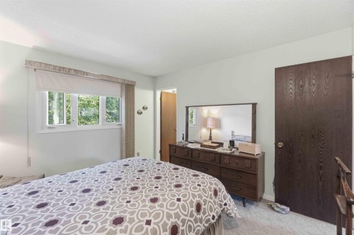 White window frame, light-colored walls, dark wood-finish door, light-colored carpeting - 30 Cavanagh Crescent, Stony Plain, AB - Indoor Photo Showing Bedroom