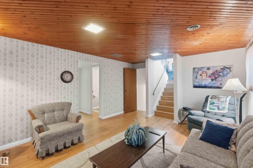 Wood-finish ceiling panels, light wood-finish flooring, staircase with wood-finish treads, and recessed lighting - 30 Cavanagh Crescent, Stony Plain, AB - Indoor Photo Showing Living Room