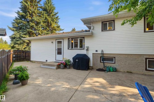 Concrete patio with direct entry, white siding, and mature evergreen trees - 30 Cavanagh Crescent, Stony Plain, AB - Outdoor With Exterior