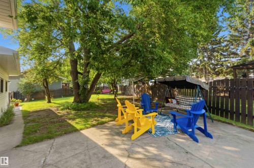 Expansive backyard featuring a concrete patio, mature trees, and privacy fencing - 30 Cavanagh Crescent, Stony Plain, AB - Outdoor