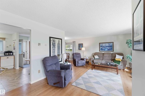 Wood-finish flooring, light-toned wall paint, recessed lighting, and a kitchen with tile flooring and light-toned cabinetry - 30 Cavanagh Crescent, Stony Plain, AB - Indoor Photo Showing Living Room
